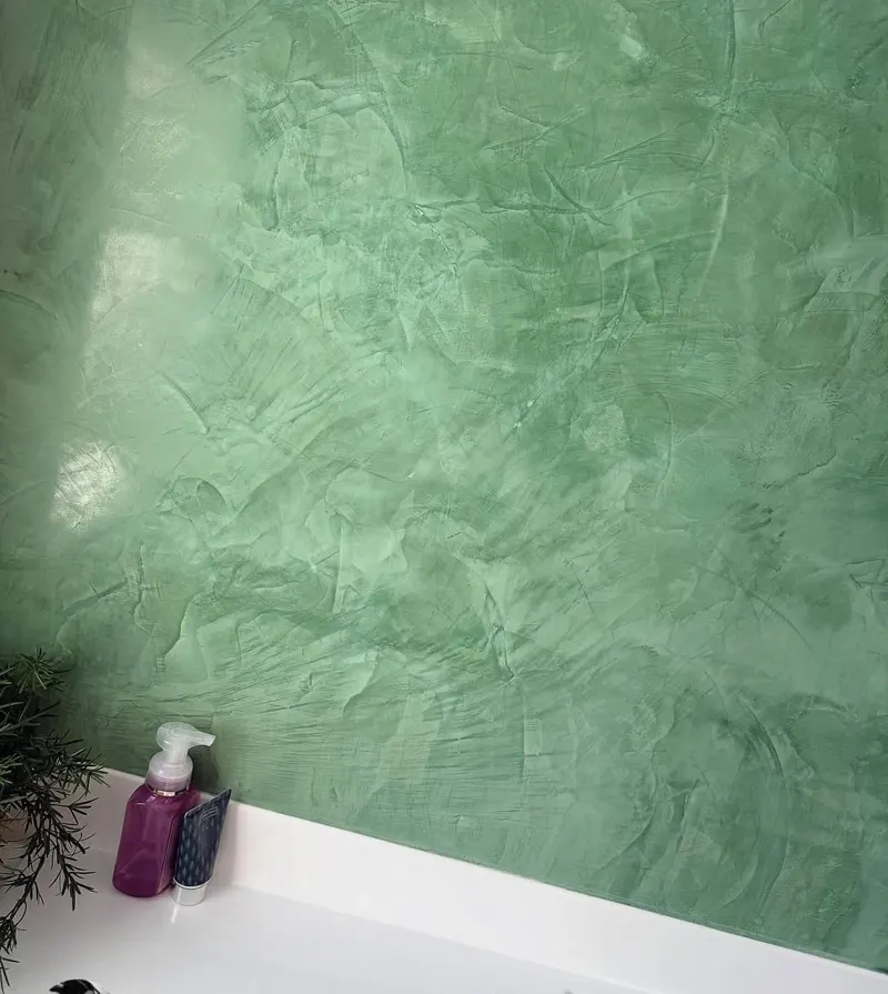 Close-up of green polished plaster above a basin, showing the trowel marks